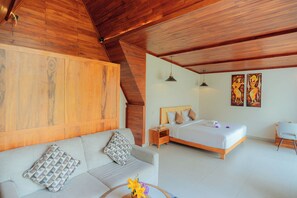 A modern bedroom with a wooden ceiling, a bed, a sofa, a small table with flowers, and two paintings on the wall.