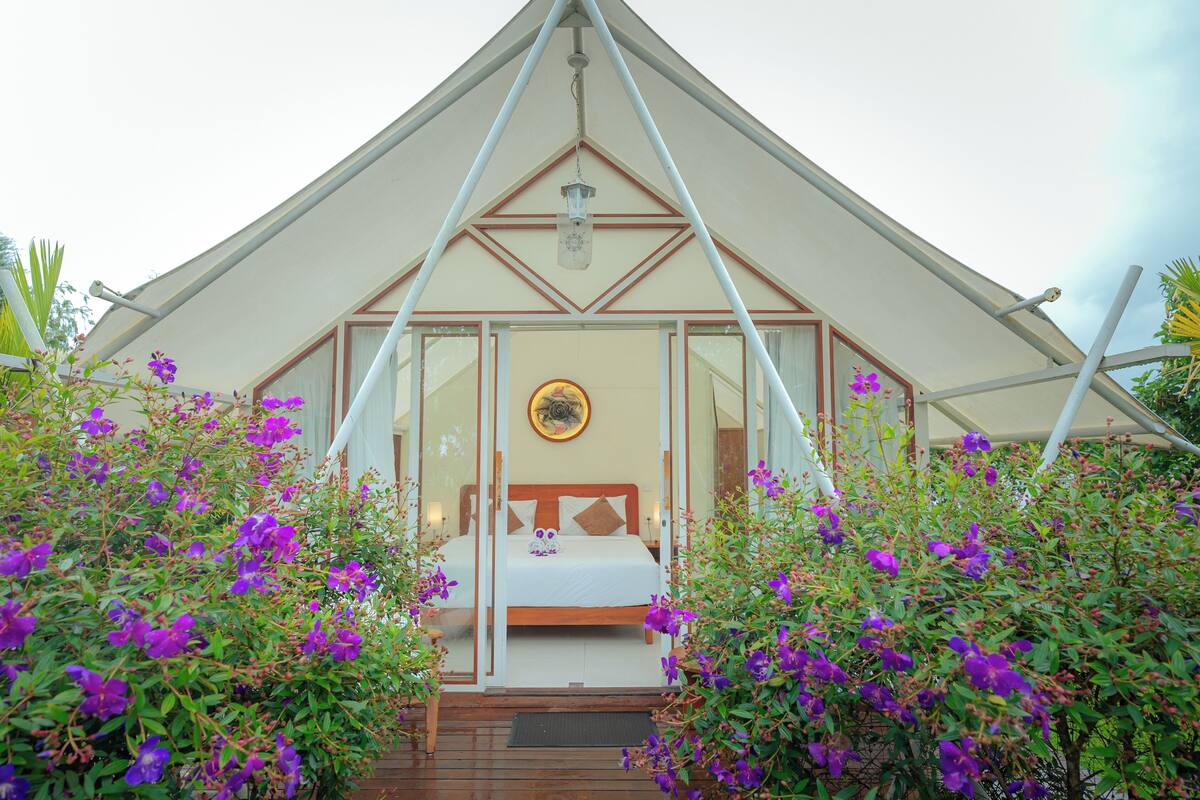 A triangular-roofed structure with a bed and a circular wall decoration.