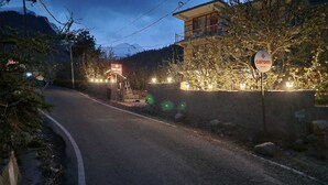 A road leading to a building with a sign for 'Carom Inn.' - Carom Inn (Manali)