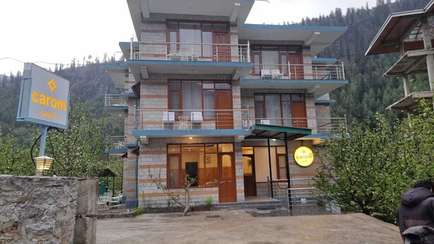 A multi-story building with a sign for 'Carom Inn.' - Carom Inn (Manali)