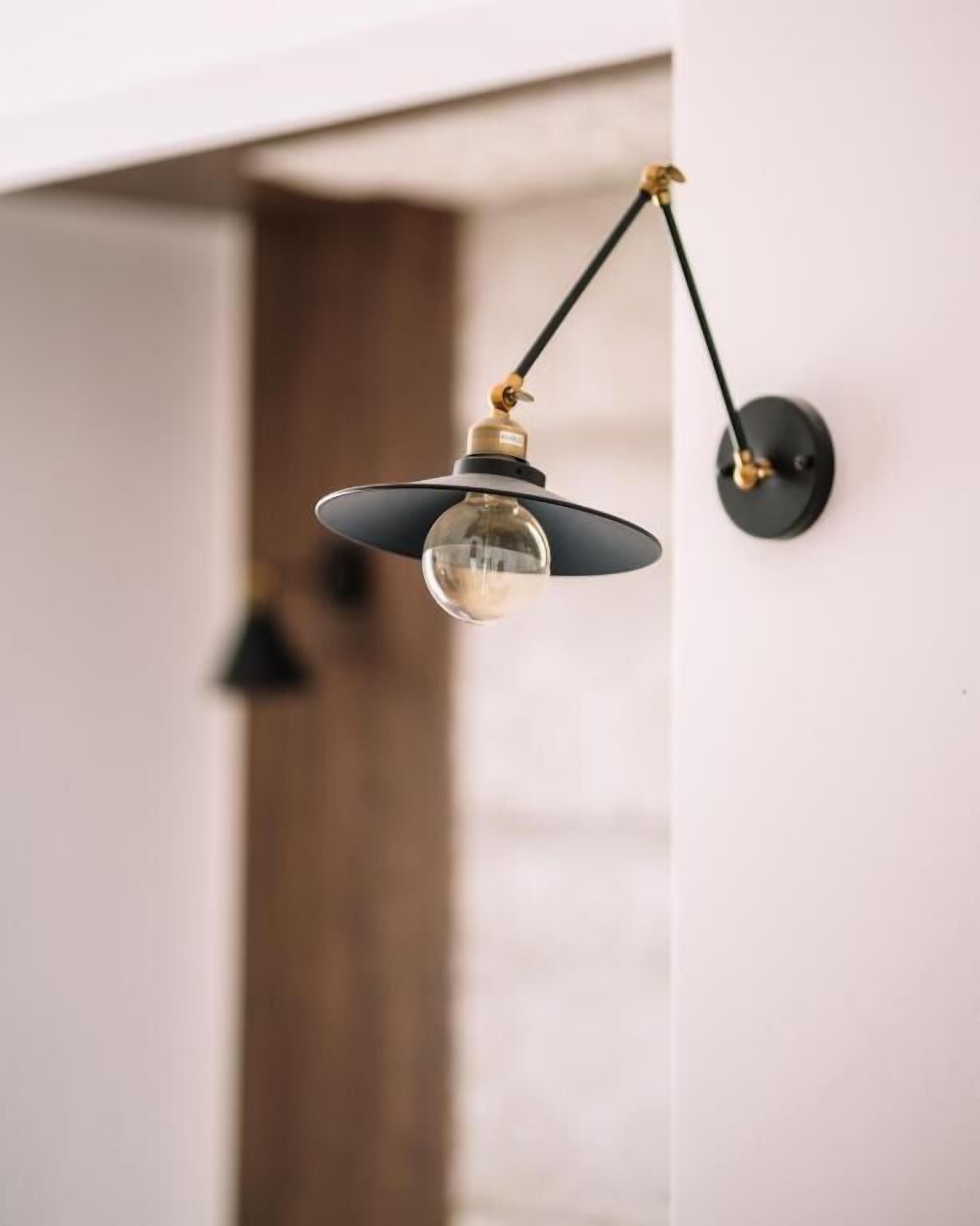 A pendant light fixture with a spherical bulb, a black shade, and a brass fixture.