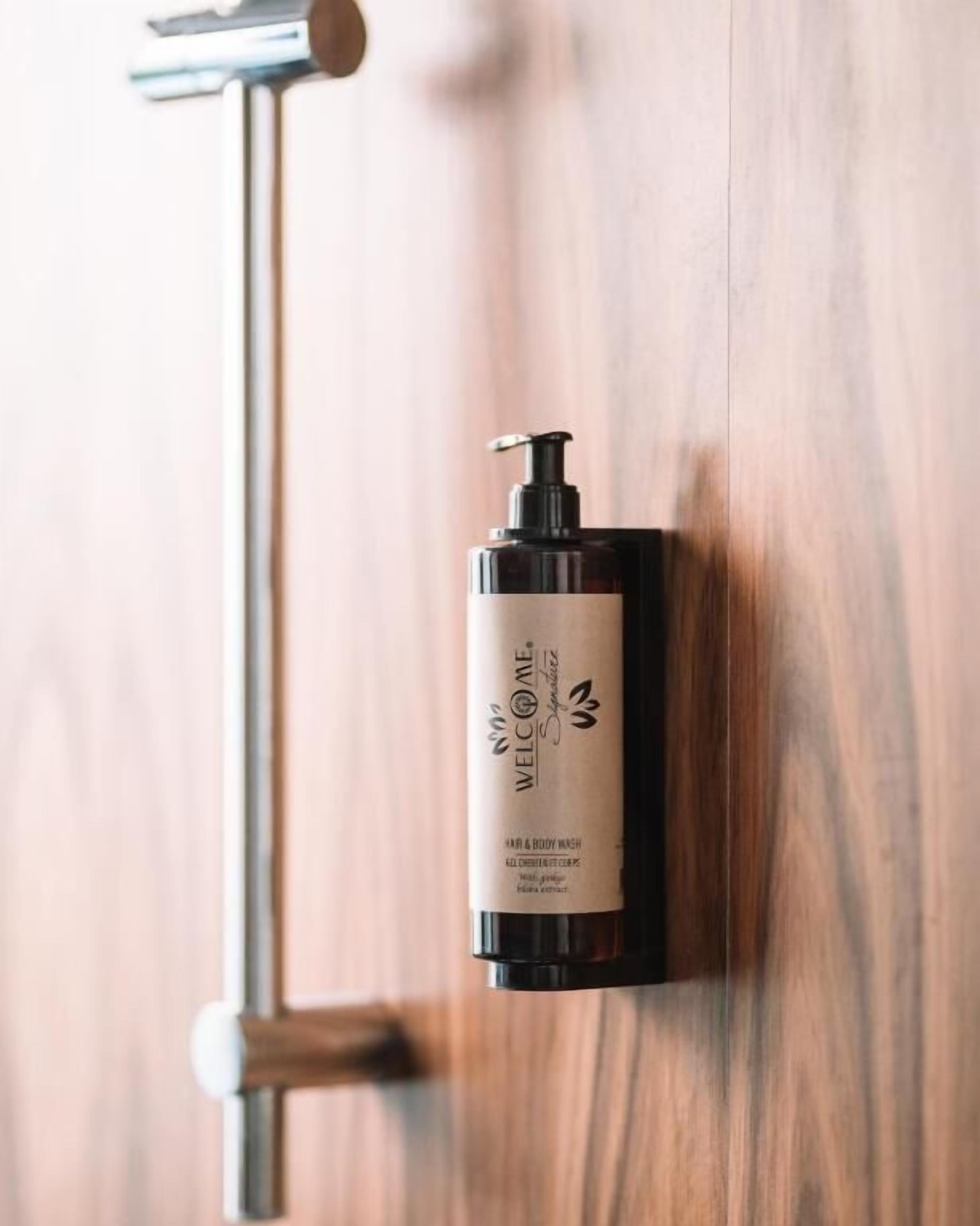 Eine Flasche Body Wash von Welcom Specialties auf einer Holztischfläche.