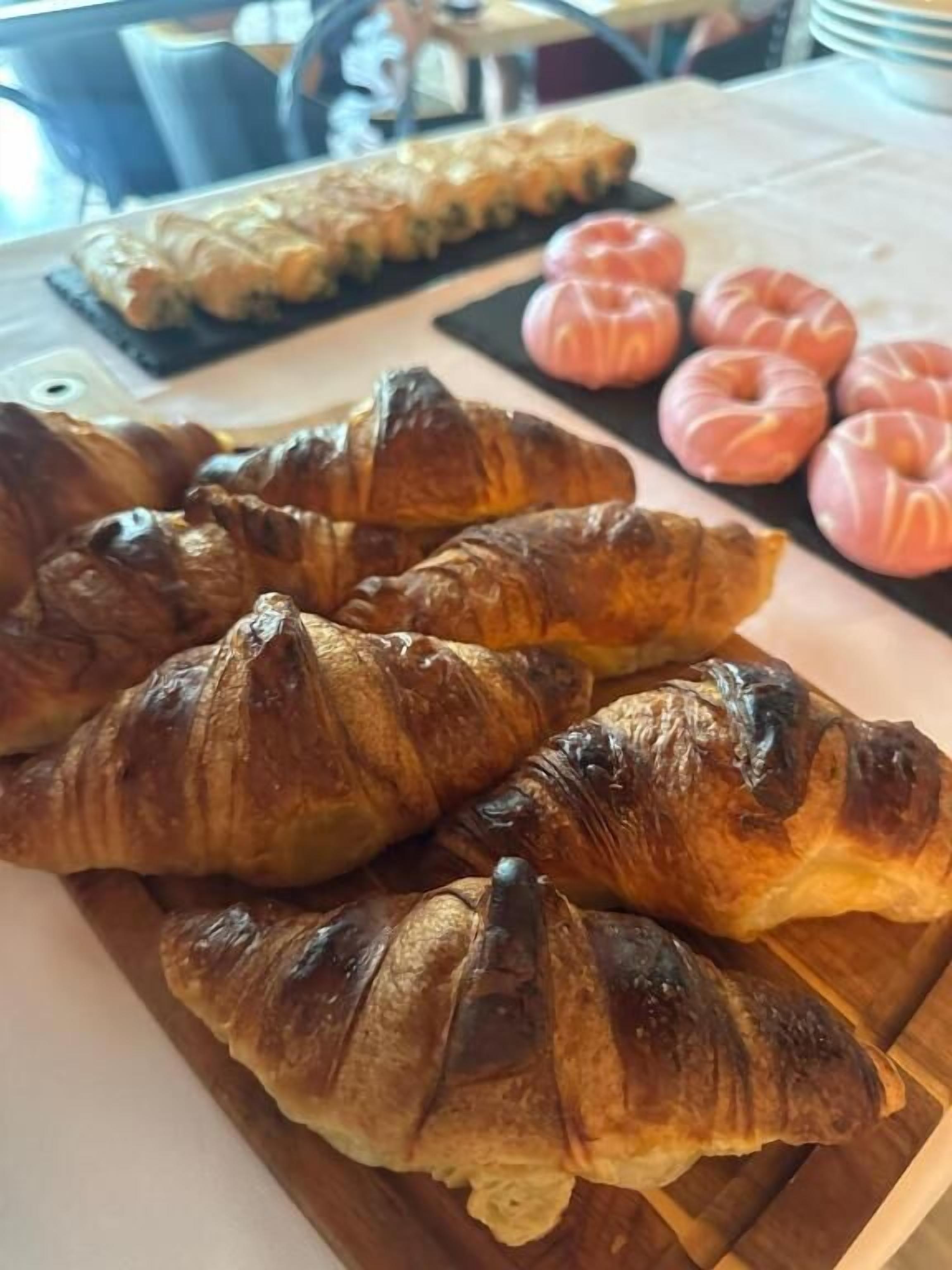 Una mesa con cruasanes y bollería.