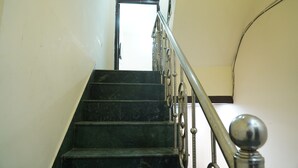 Una escalera con barandilla de metal y una puerta al final.