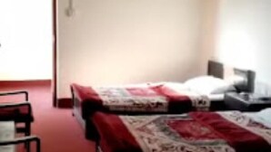 Une chambre d’hôtel avec un lit, un bureau et une chaise.