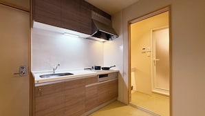 A compact kitchen with a built-in stove, sink, and cabinets. - Namiki Hills (Hiroshima)