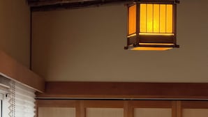A traditional Japanese room with tatami flooring, a shoji screen, and a hanging paper lantern. - Namiki Hills (Hiroshima)