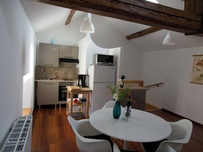 Une cuisine compacte équipée d’un four à micro-ondes, d’un évier et d’une table en bois avec des chaises.