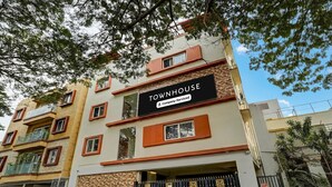 A multi-story building with a sign reading 'TOWNHOUSE Company-Serviced.' - Deluxe Venkat Inn (Bengaluru)