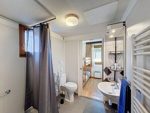 Ein kleines Badezimmer mit Dusche, Toilette und Waschbecken.