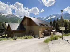 Ein rustikales Berglodge mit Metalldach, Holzfassade und einem Schild mit der Aufschrift 'La Residence'.