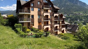 Un hôtel à plusieurs étages, doté de balcons, situé dans un cadre montagneux.