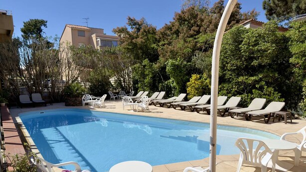 Una piscina amb gandules i plantes en testos.