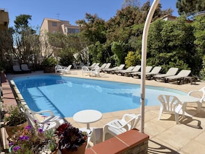 Una piscina con sillas de descanso y plantas en macetas.