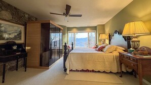 Una camera da letto con un letto, una scrivania, una lampada e vista sull'esterno.