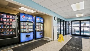A lobby with vending machines, a clock, and a caution wet floor sign. - Oceanfront 1BR + Beach Access + Dog Friendly (Myrtle Beach)