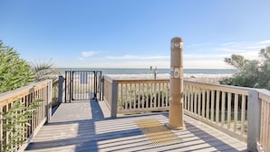 A wooden deck with a metal railing leading to a beach view. - Oceanfront 1BR + Beach Access + Dog Friendly (Myrtle Beach)