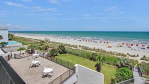 A beach view from a balcony with outdoor seating and a pool. - Oceanfront King Room + Beach Access + Dog Friendly (Myrtle Beach)