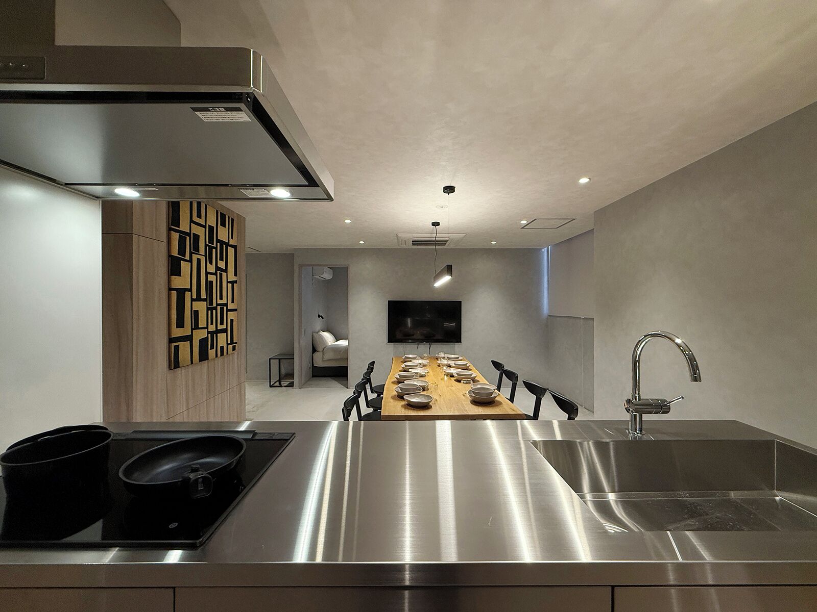 A modern kitchen with a central island, stainless steel appliances, and a built-in TV.