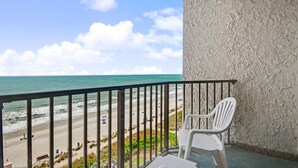 Un balcón con vista a la playa y al océano.