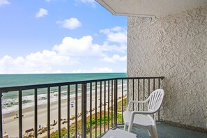 Un balcon avec vue sur la plage et l’océan.
