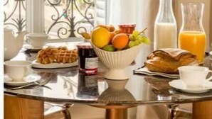 Ein Frühstückstisch mit einer Obstschale, Waffeln und einem Glas Orangensaft.