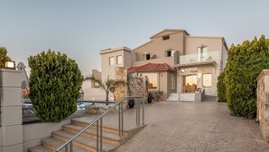 Un edificio moderno con piscina, escalones de piedra y un balcón de cristal.