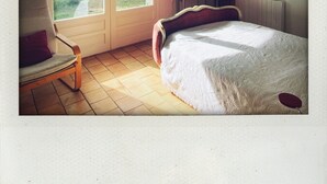 A bedroom with a bed, a chair, a desk, a lamp, and a window. - La Grande Bastide (Grambois)
