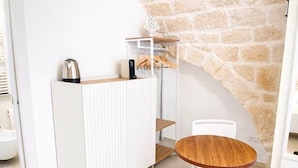 Een moderne kamer met een witte radiator, een houten tafel en een witte stoel.