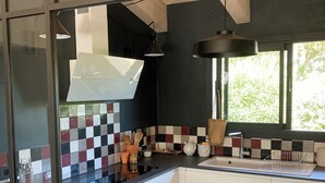 Une cuisine moderne avec un dosseret à carreaux noirs et blancs, un évier en acier inoxydable et un lave-vaisselle.