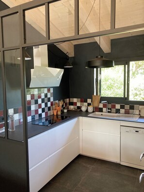 A modern kitchen with a black and white checkered backsplash, a stainless steel sink, and a dishwasher. - Waterfront stone house, fully renovated in 2021 (Sainte Lucie de Porto Vecchio)