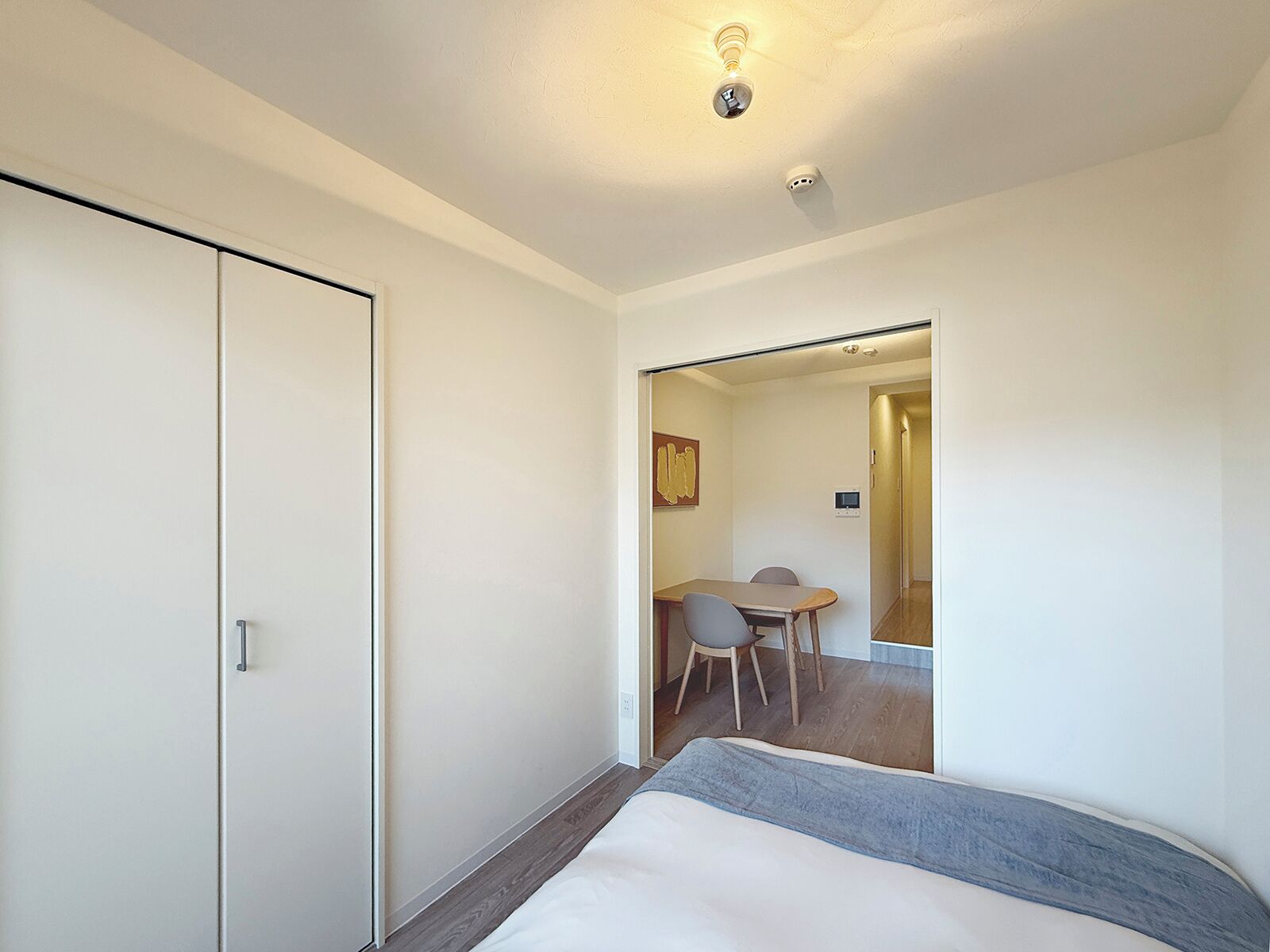 A hotel room with a bed, a desk, and a chair.
