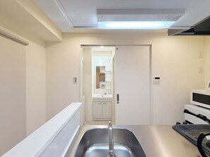 A modern bathroom with a sink, mirror, and a shower area.