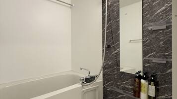 Appartement Affaires, balcon | Salle de bain | Ensemble baignoire-douche, séchoir à cheveux, pantoufles