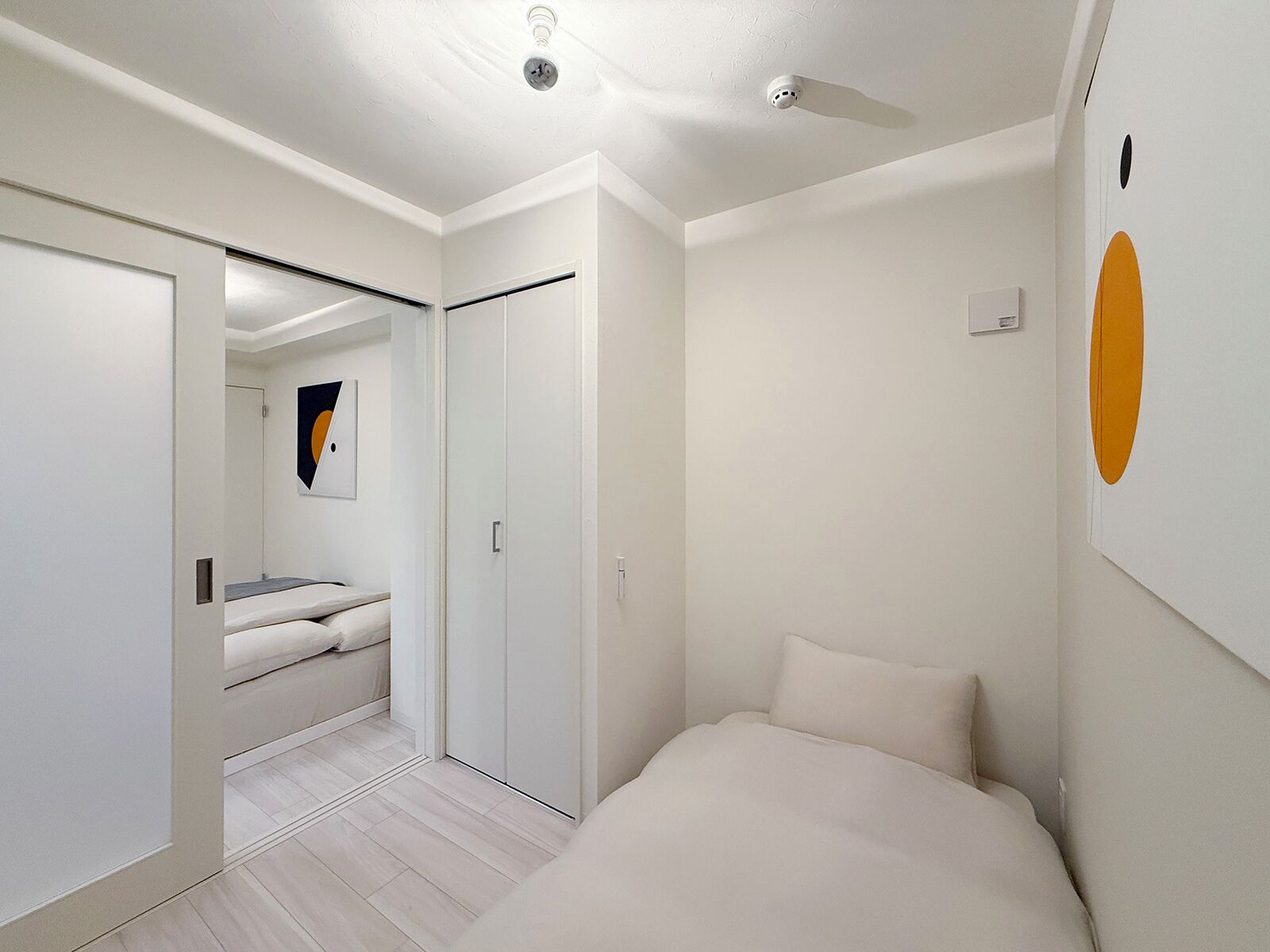Une chambre à coucher moderne, dotée d’un lit, d’un dressing et d’une salle de bain avec un miroir.