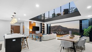 Ein modernes Interieur mit Küche, Essbereich und einem Balkon mit Bergblick.