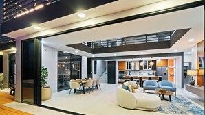 Ein modernes Interieur mit Essbereich, Sofas und einer Küche.