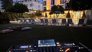 A DJ booth with a control panel and turntables, surrounded by outdoor seating and a building in the background. - LA MUER CITY HOTEL KEMER (Kemer)