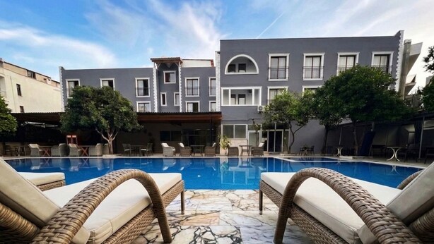 A swimming pool with lounge chairs, a building with balconies, and trees. - LA MUER CITY HOTEL KEMER (Kemer)