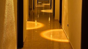 A hotel hallway with doors on both sides, a tiled floor, and wall-mounted lighting. - LA MUER CITY HOTEL KEMER (Kemer)