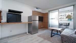A compact kitchen with a built-in stove, a refrigerator, and a window overlooking a balcony. - Sophisticated Retreat Near the Sea, Agde (Agde)