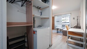 A compact room with a washing machine, a small table, and a chair. - Sophisticated Retreat Near the Sea, Agde (Agde)