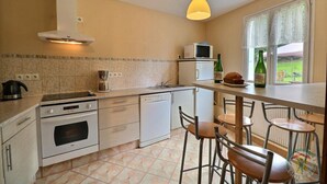 A kitchen with a stove, oven, microwave, and a window with a view. - The Monthorin Valley (La Bazouge-du-Désert)