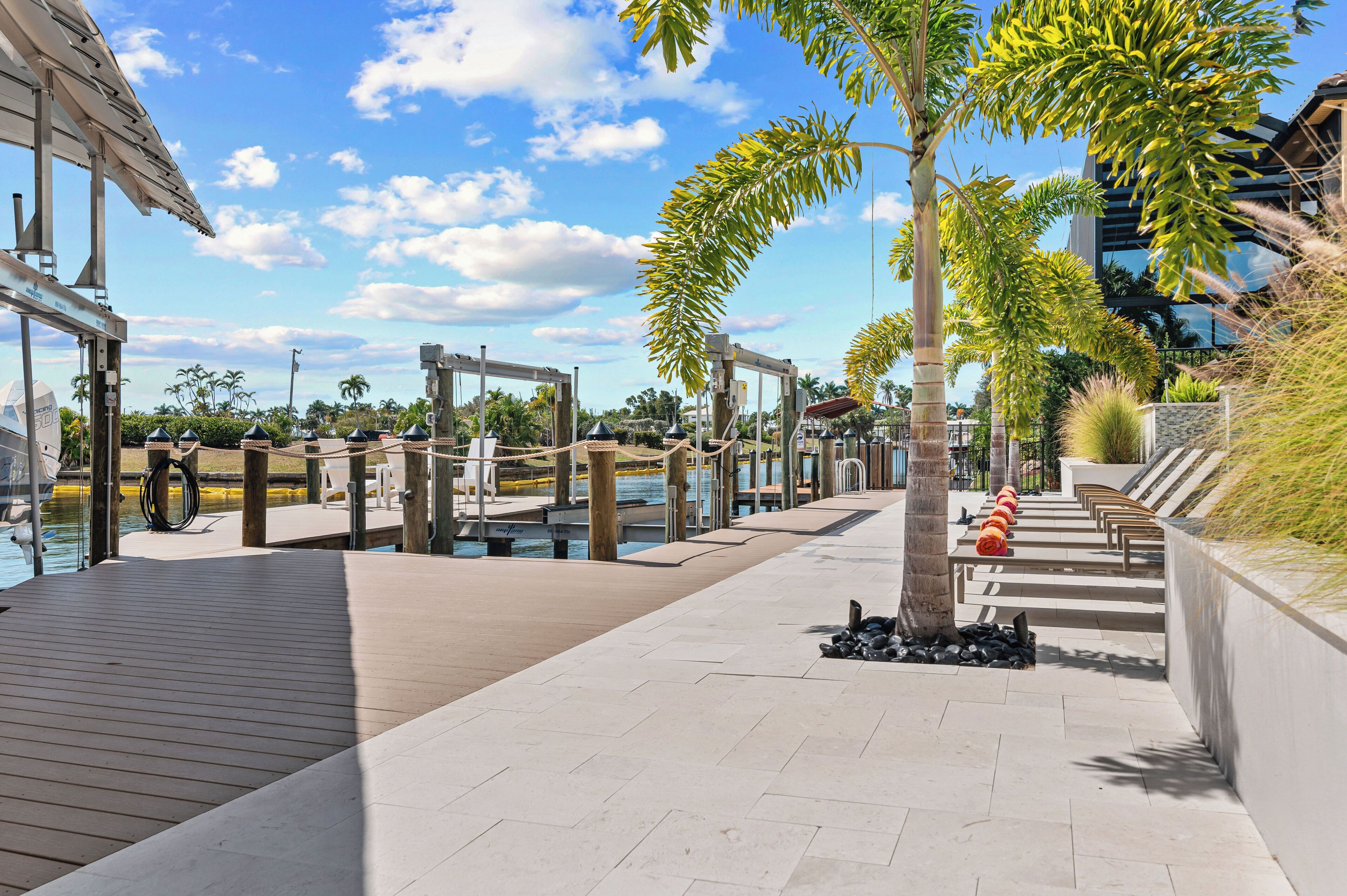 Eine Uferpromenade mit Holzdeck, Sitzbereichen und Blick auf das Wasser.