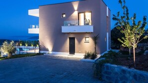 Un bâtiment moderne à deux étages, doté d’un balcon, d’une porte et d’une petite fenêtre.