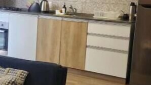 Una cocina moderna con armarios de madera, microondas y refrigerador.