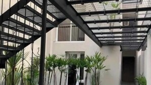 Un espacio al aire libre cubierto con una escalera de metal, plantas en macetas y un camino de baldosas.