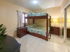A room with a bunk bed, a desk with drawers, a lamp, and a potted plant. - Relaxing Oceanview Condo Pools Beach (Puerto Peñasco)
