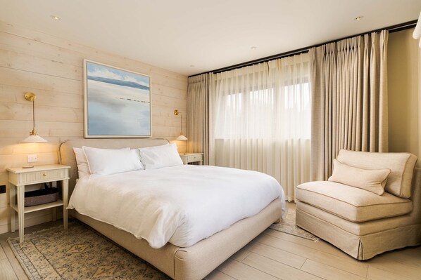 A bedroom with a bed, bedside tables, a chair, a painting, and curtains. - Spacious Countryside Home Yoga Studio (Haverfordwest)