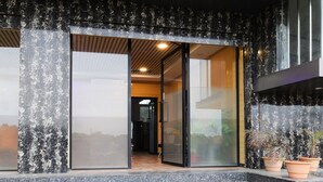 A modern building entrance with a marble facade, a glass door, and a staircase leading to the entrance. - Deluxe Super Collection O Kollur Prime (Hyderabad)